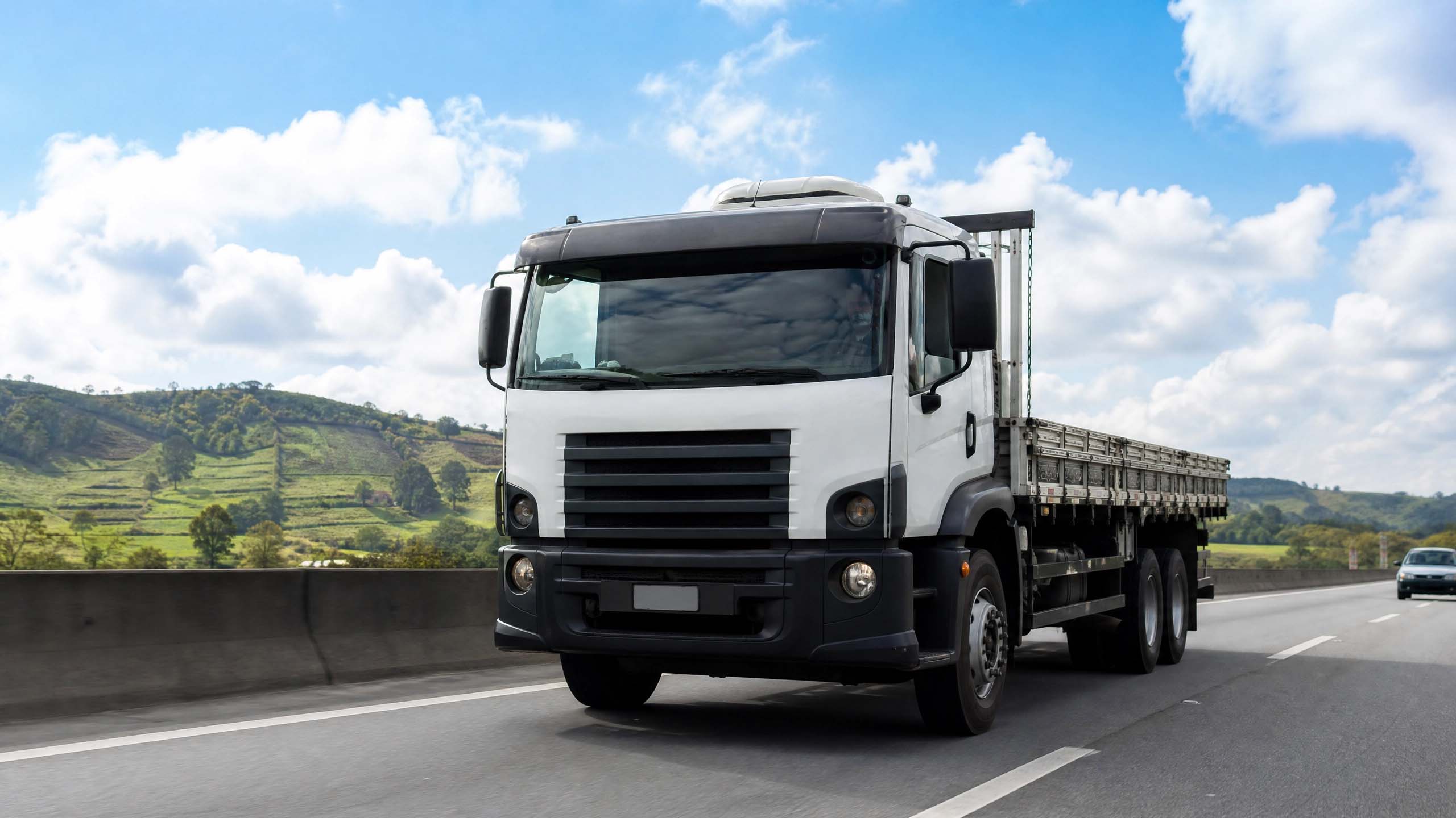 Caminhão Volvo de linha pesada em rodovia com paisagem ao fundo